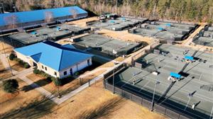 Tennis facility with outdoor courts, indoor court facility, and office building. 